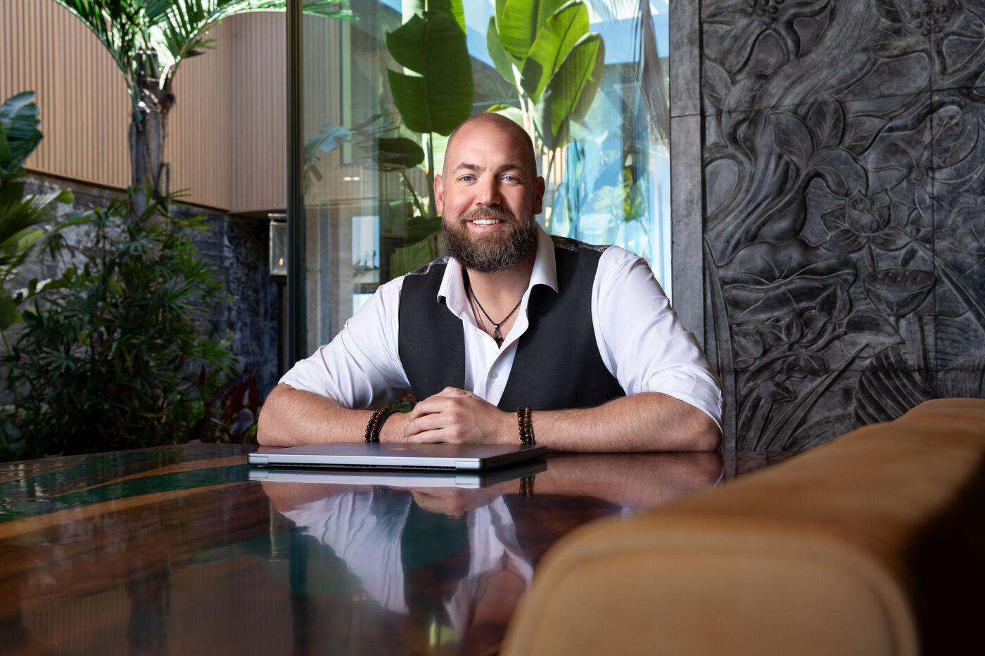 Dalton Locke seated at the table, hands resting on a closed laptop