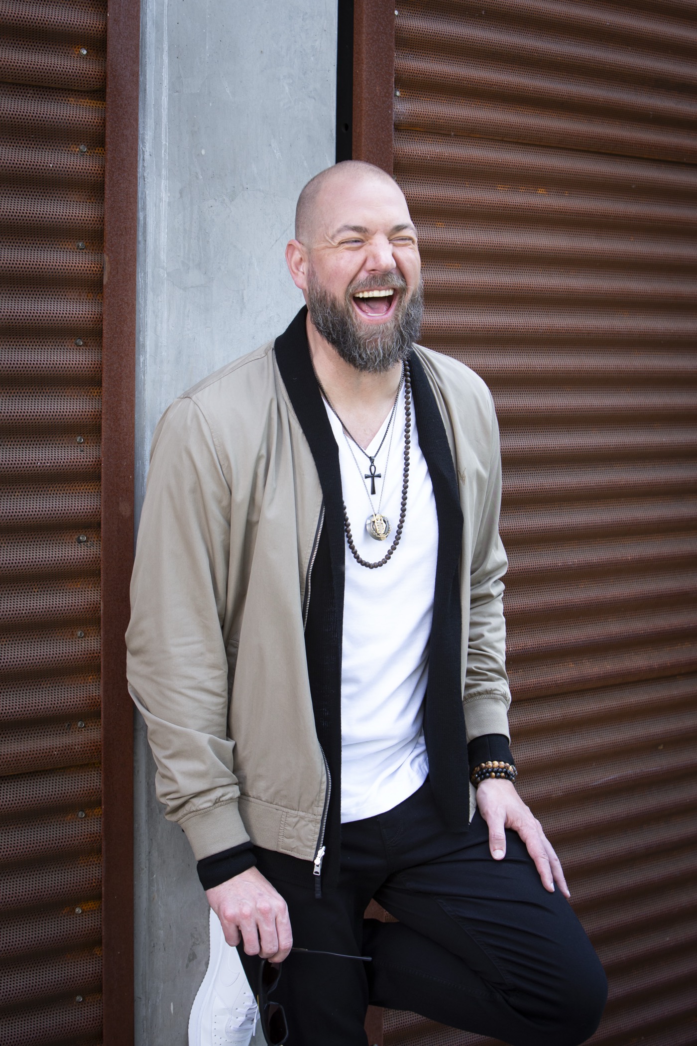Dalton Locke laughing on the street against a rust steel wall